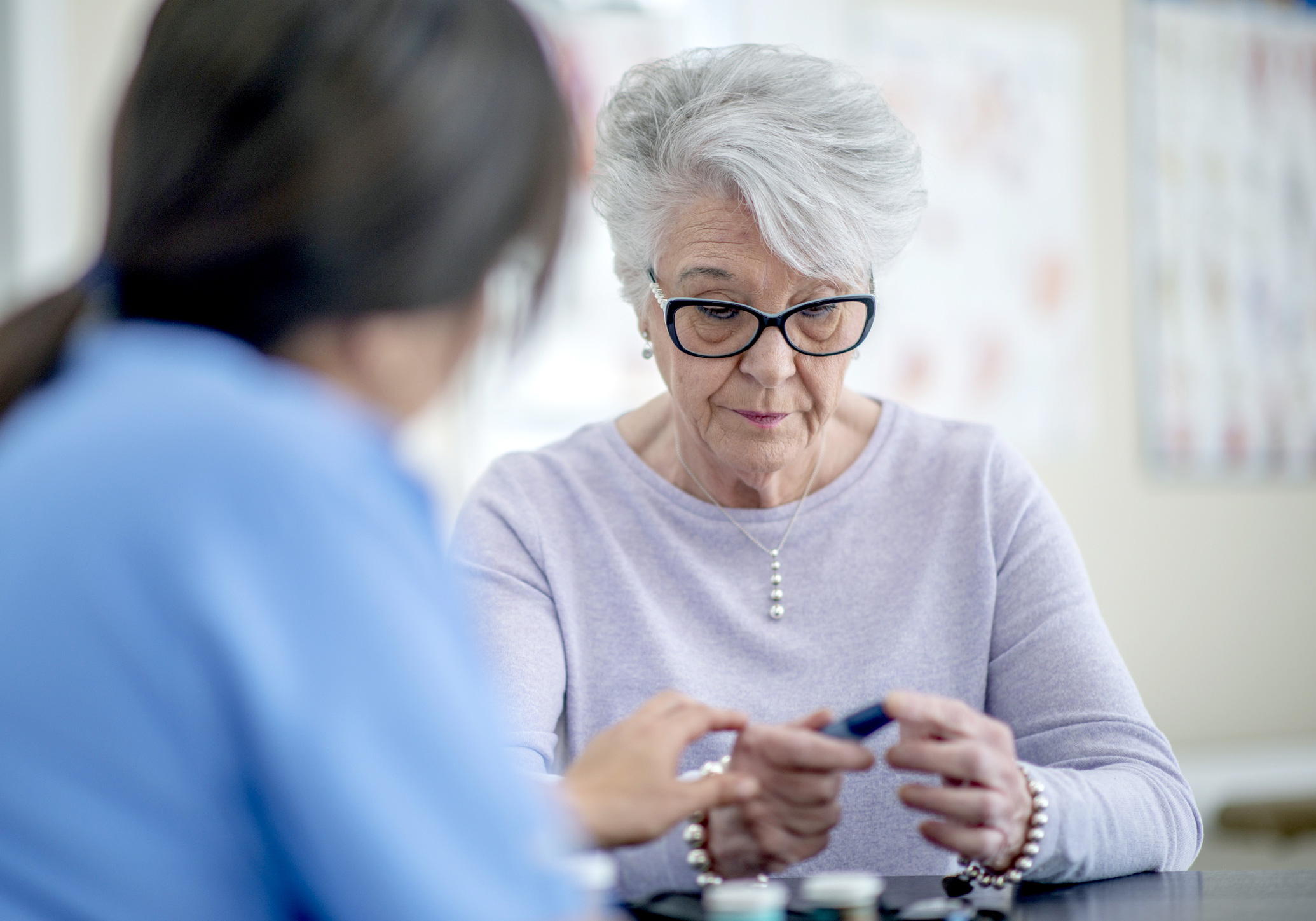 Doctor meets with diabetic senior woman at medical appointment